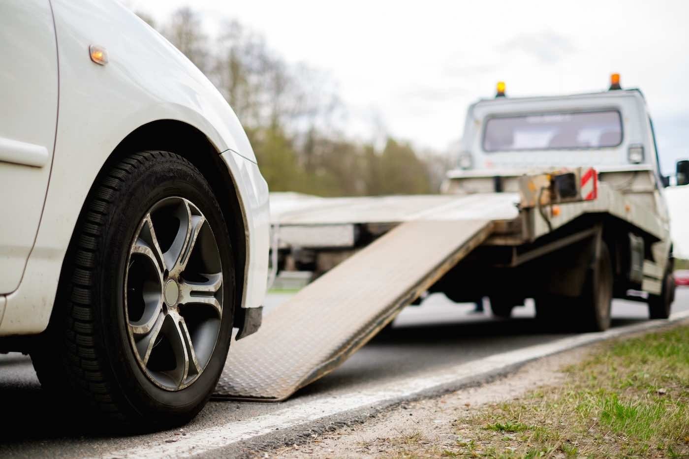 Winnipeg-Towing-flatbed towing car driving on